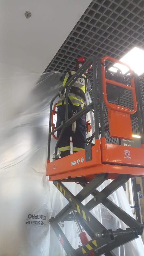 Operador LES em plataforma tesoura — trabalho em teto no aeroporto Salgado Filho