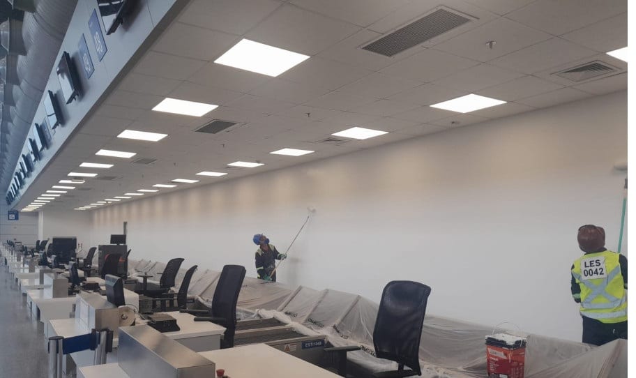 Equipe LES em pintura do hall de check-in do aeroporto